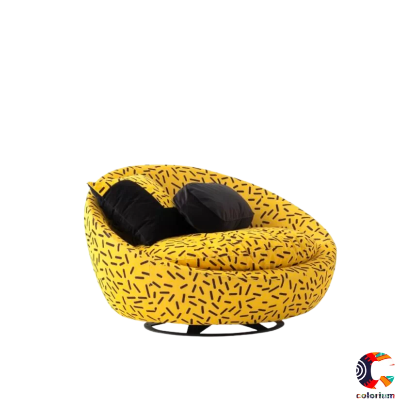 Vibrant yellow accent chair with a bold black brushstroke pattern, featuring a rounded swivel base and two black throw pillows.