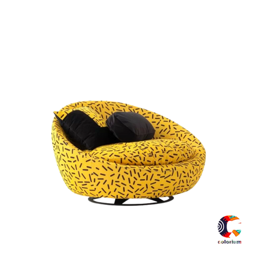Vibrant yellow accent chair with a bold black brushstroke pattern, featuring a rounded swivel base and two black throw pillows.